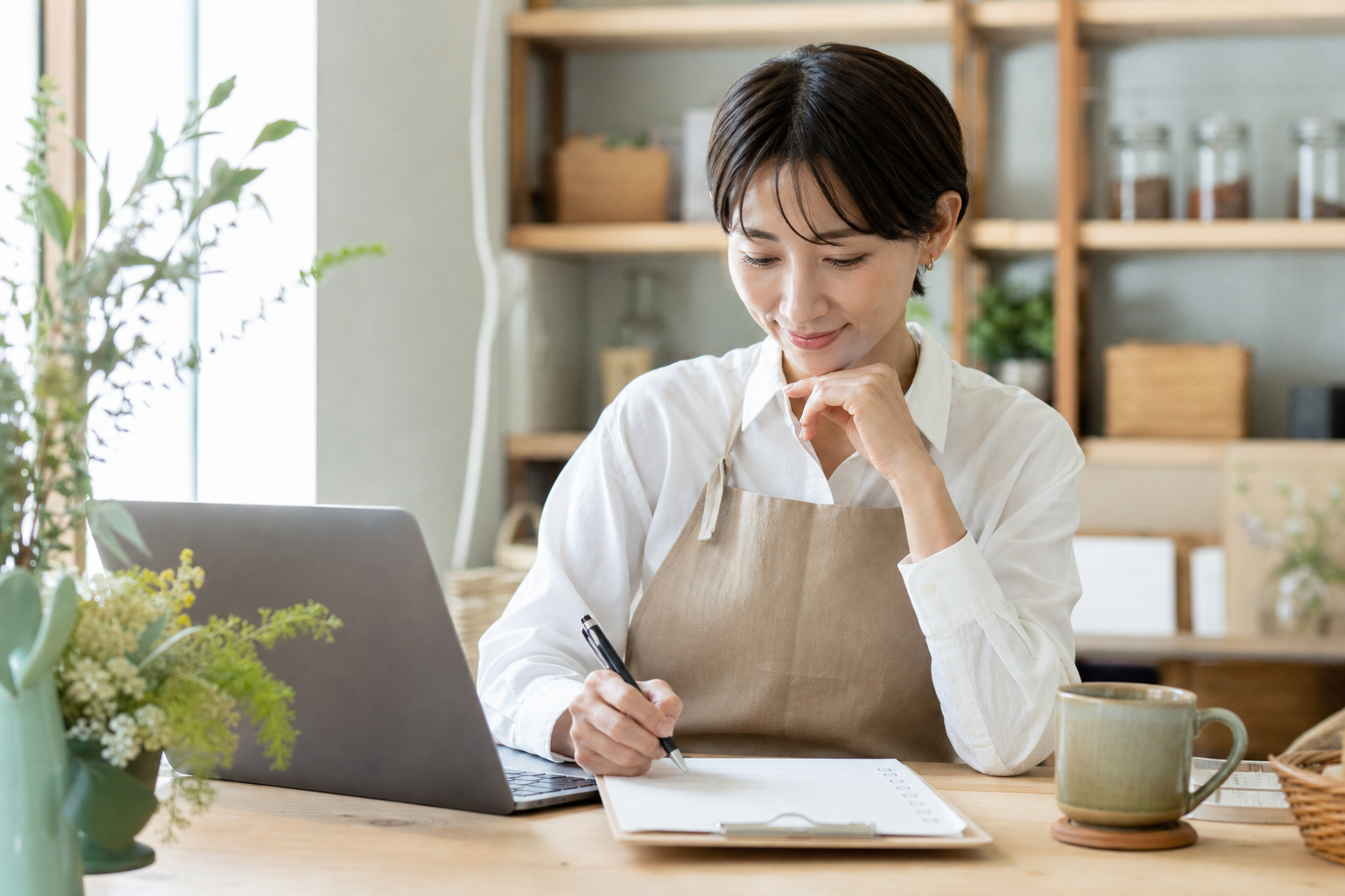 店舗経営者が補助金の公募情報を確認してメモしている様子